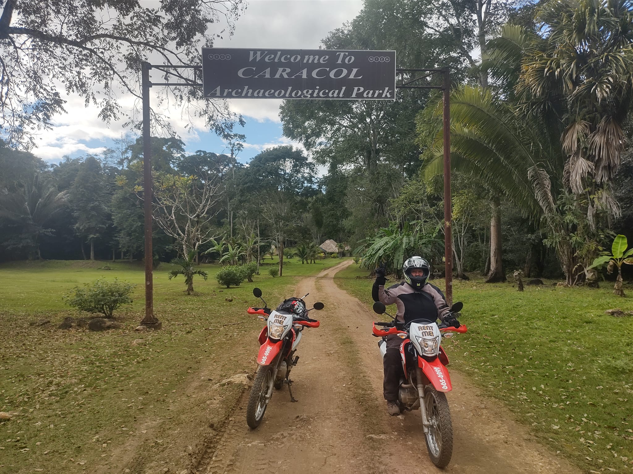 Two motorcycles in front
        of the entrance to Caracol, a Mayan archeological site in
        Belize.