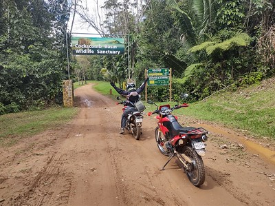 motorcycles at the muddy entrance of Cockscomb WIldlife
        Sanctuary