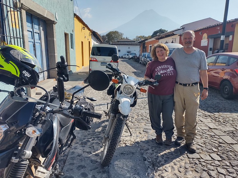 happy couple pose with their motorcycles