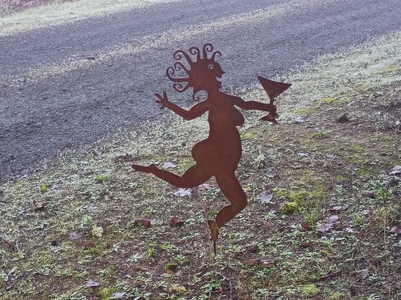 metal statue of a
        naked, fat, happy woman with a cocktail
